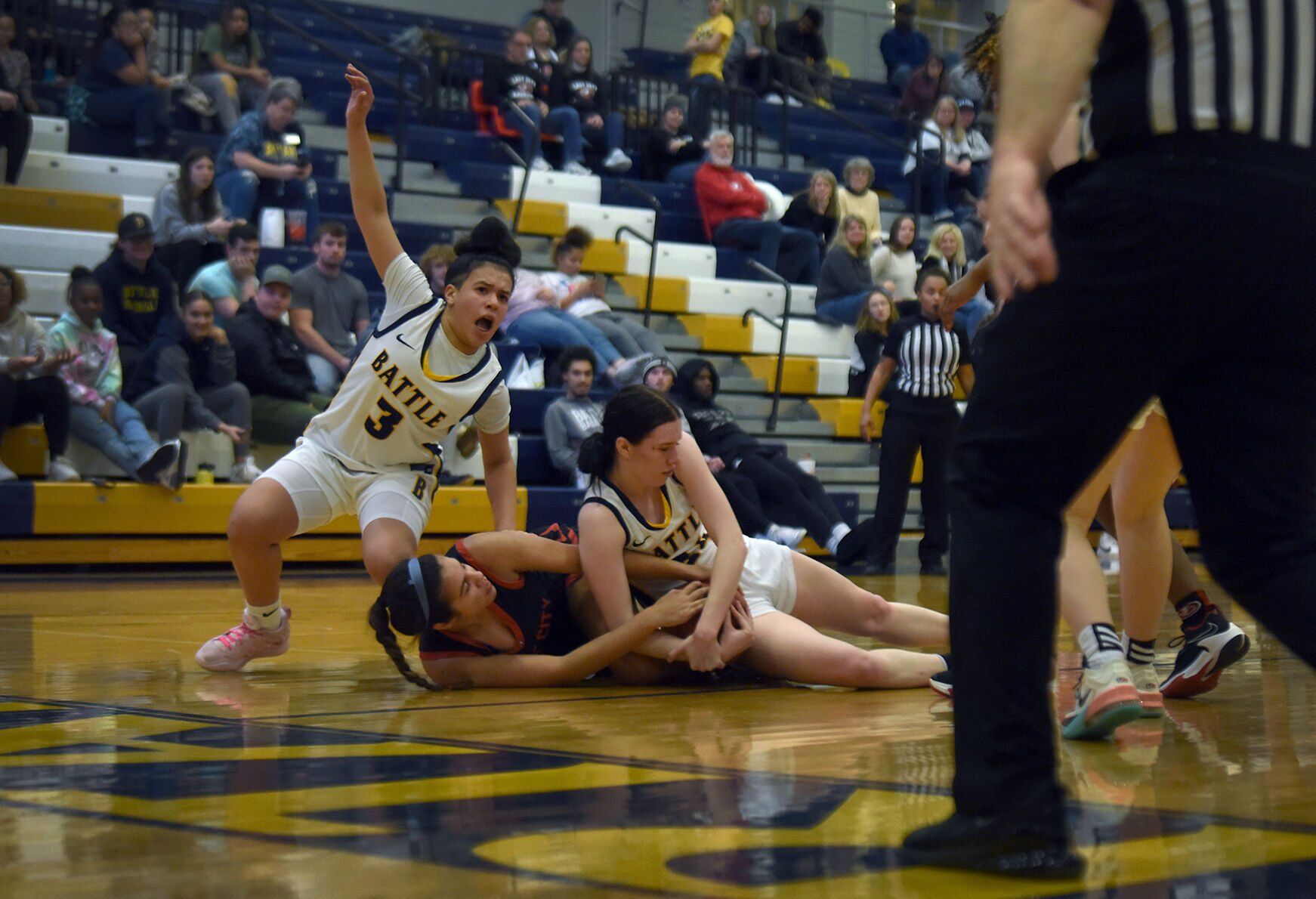 From left, Battle’s Tayla Robinson, 3, reacts as Kaelyn Johnson, 24, and Isabel Schmidt, 14, wrestle for the ball
